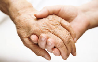 joven dando la mano a anciana
