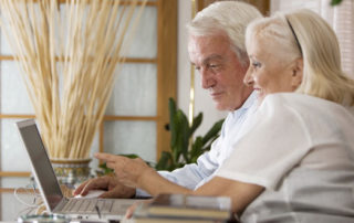 anciano y anciana consultando en el ordenador