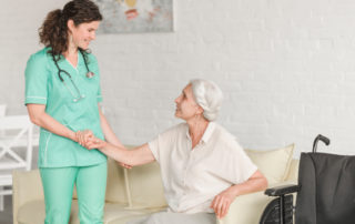 enfermera ayuda a paciente mayor a levantarse